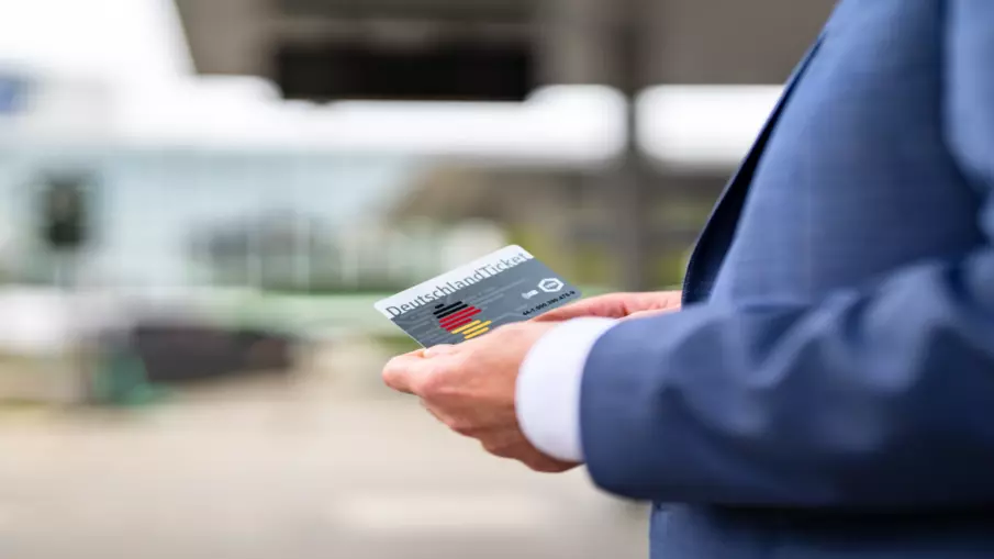 Das DeutschlandTicket in der Hand eines Mannes